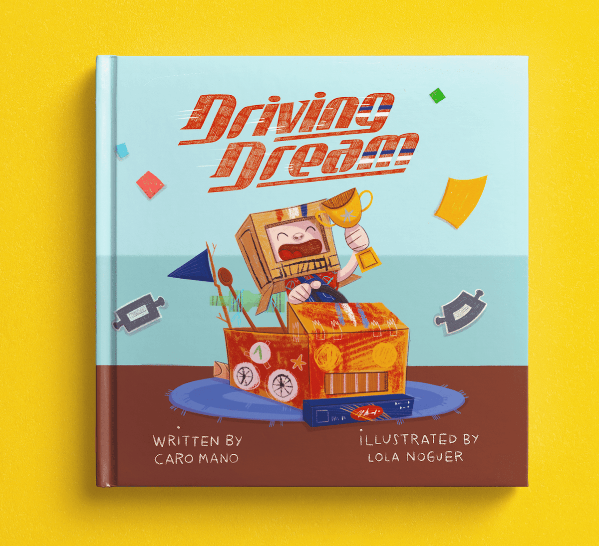 Driving Dream personalized book hardcover with a child in a cardboard-box race car holding a trophy